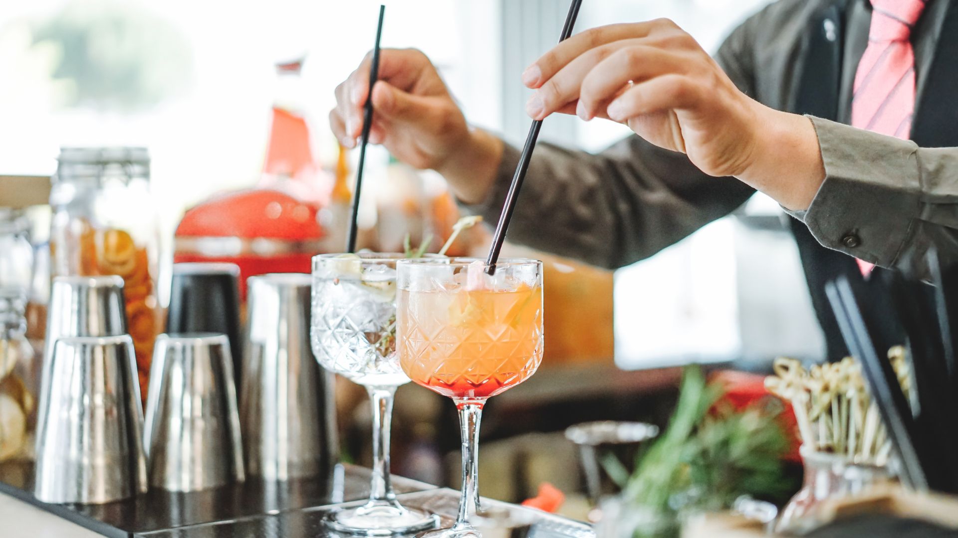 A bartender is making a drink at a bar