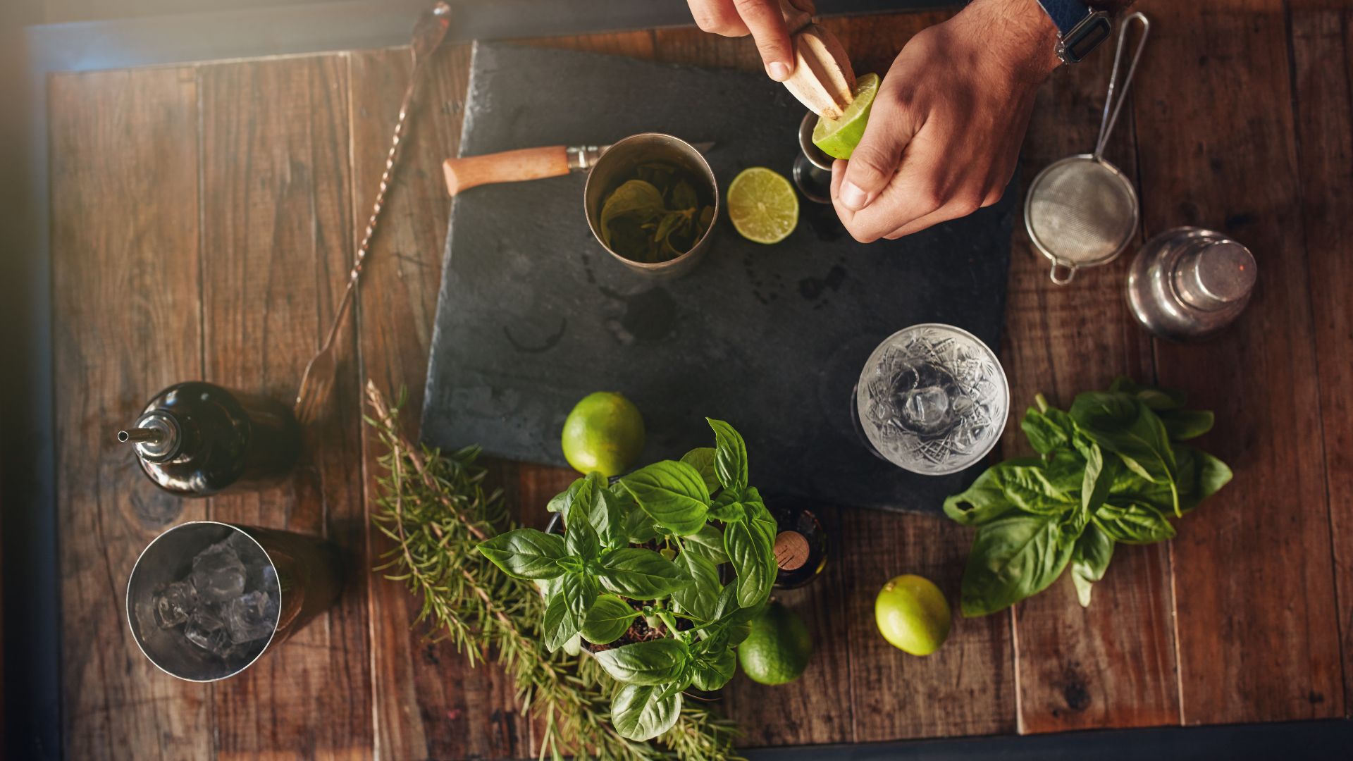 A person cutting up a lime on a cutting board