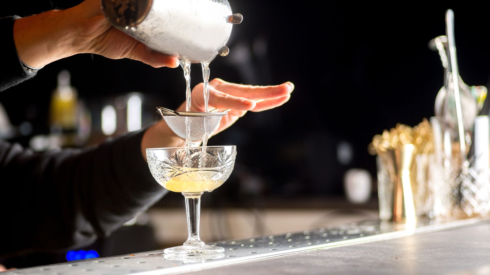 A person pouring a drink into a glass