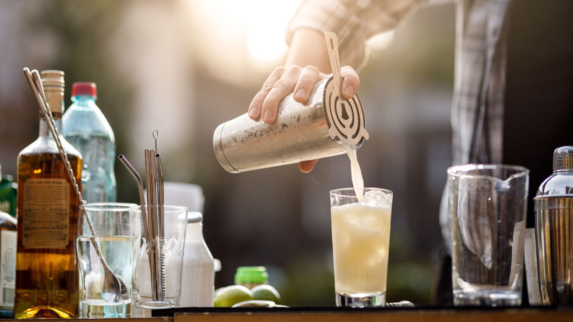 A person pouring a drink into a glass